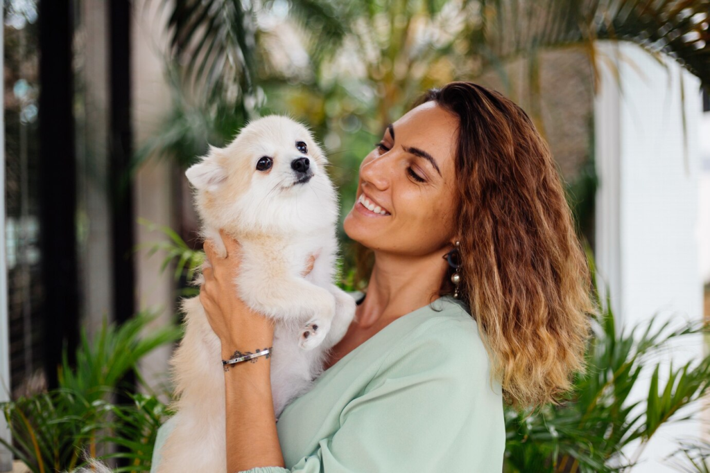 Mulher com cachorro de raça pequena. Ótimo para apartamento.